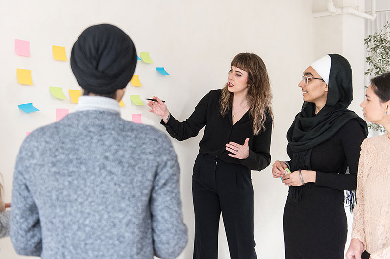 minerva bc women collaborating and learning to lead with examples on wall