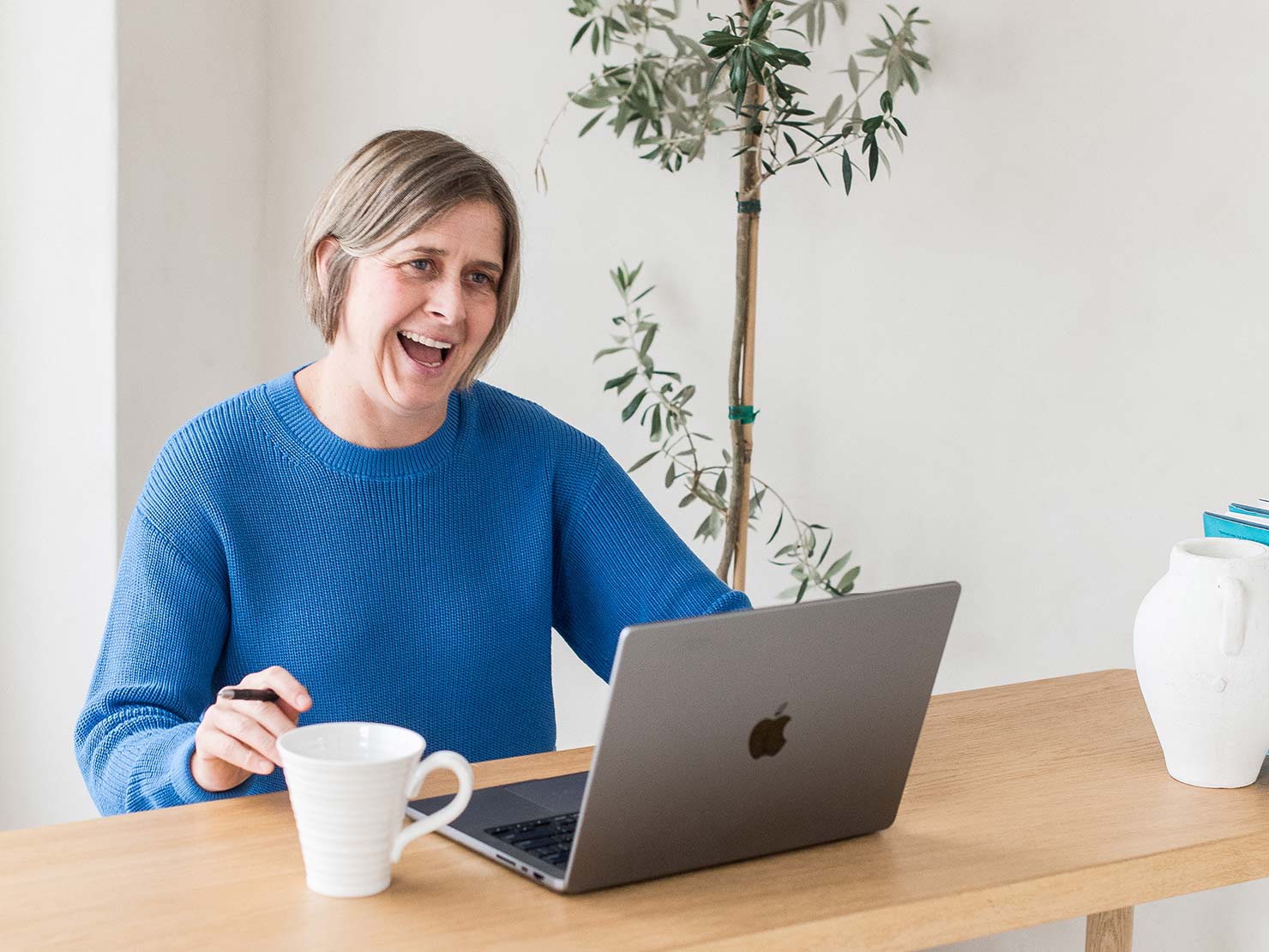 minerva bc woman working at table with laptop and beverage