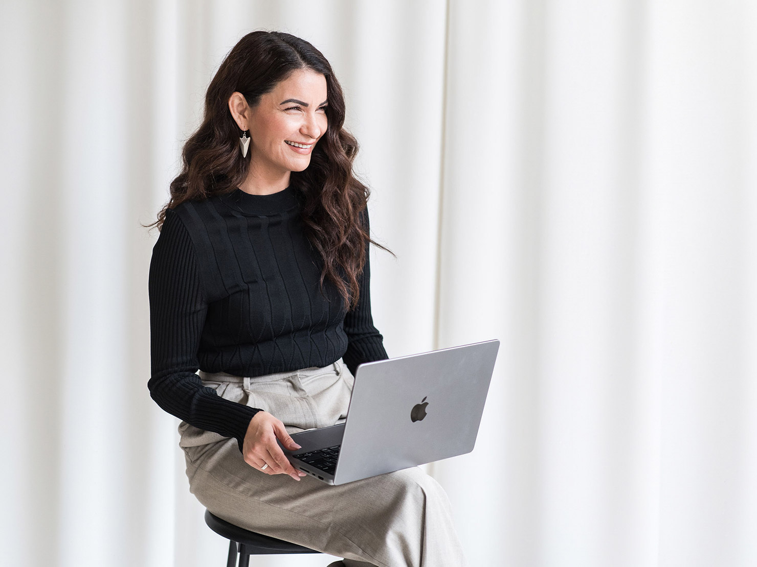 minerva bc smiling dressed up woman sitting on chair with laptop 2