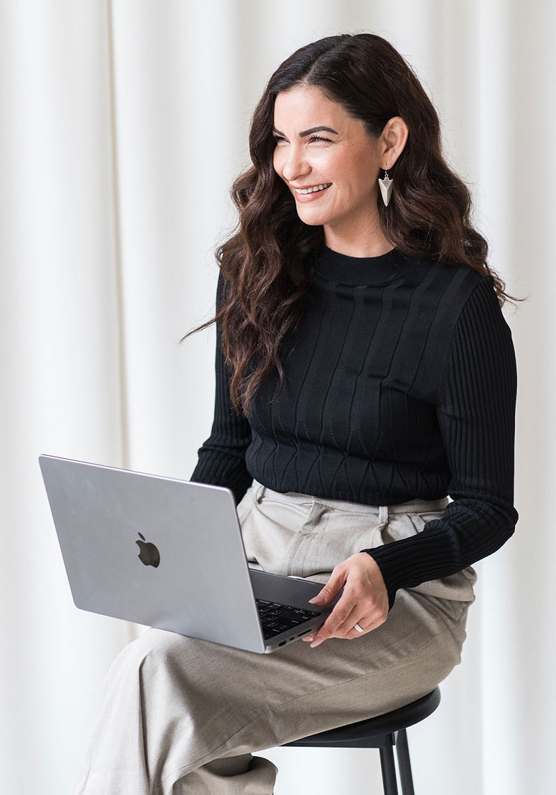 minerva bc smiling women wearing business casual clothing with laptop sitting
