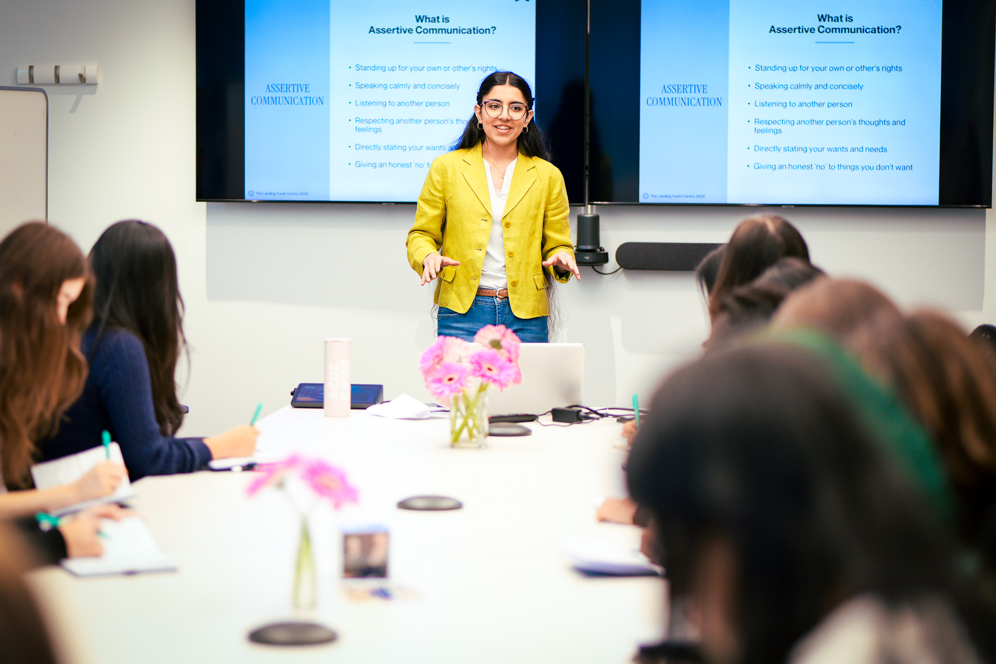A young woman stands in front of a presentation